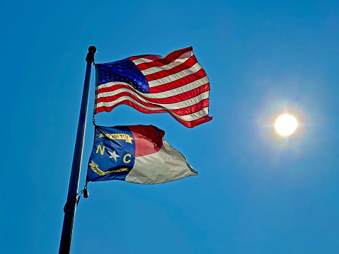 New York Flag flying in the wind with beautiful sky on the background.