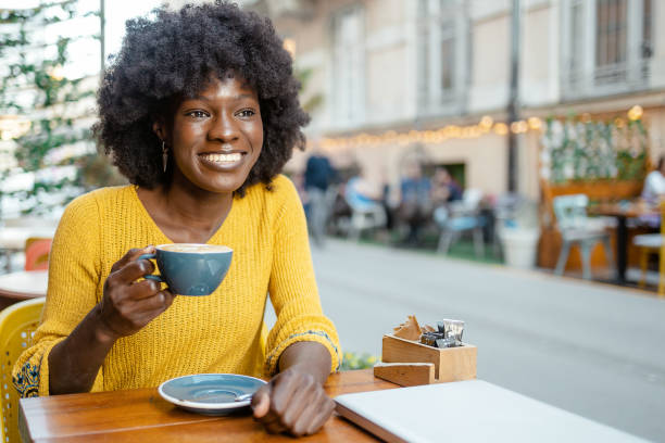 istock Black Woman Drinking Coffee in Cafeteria 1587281500