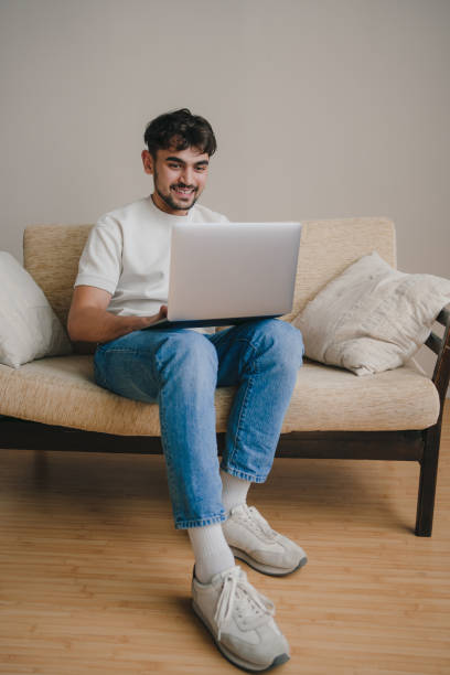 istock Man working on laptop in living room 1587294660