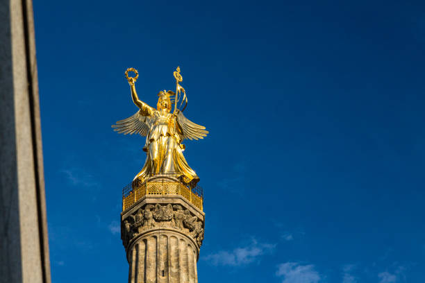 Stuttgart, Germany, 2011 - Famous landmark: golden Hermes statue on a column near Schlossplatz against a blue sky