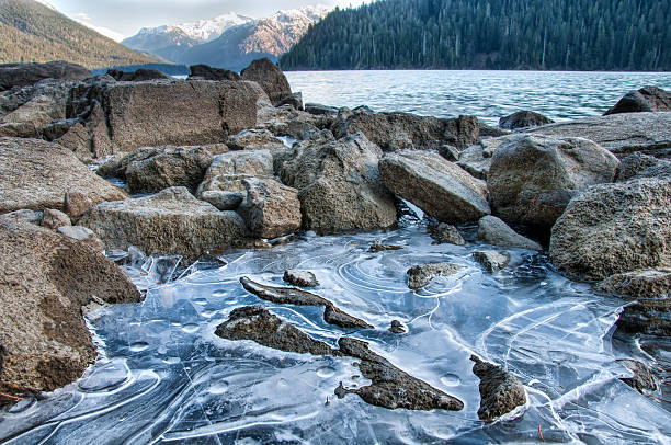 Frozen ice in rocks along lakeside stock photo