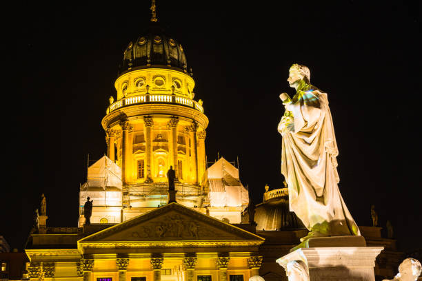 istock Lighted up German cathedral and Schiller statue in Gendarmenmarkt, Berlin, Germany 1587362078