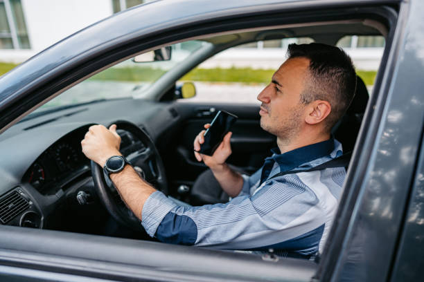 Handsome young man listening to music while driving a car on the street during the day.
