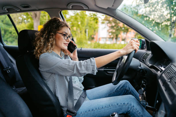 istock Young Woman Talking On The Phone While Driving A Car 1587401626