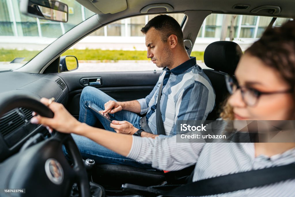 Driving Test Using A Tablet Young Driving Instructor Grading His Female Student Using A Tablet ...