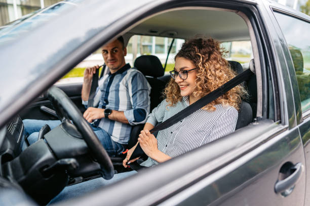 Driving Instructor And A Female Student Fastening Their Seatbelts
