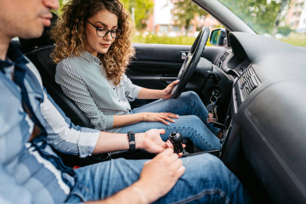 istock Young Woman Having A Driving Lesson With A Male Driving Instructor 1587425388