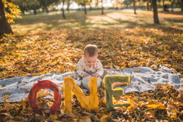 istock One-year-old girl is playing in the park 1587426529