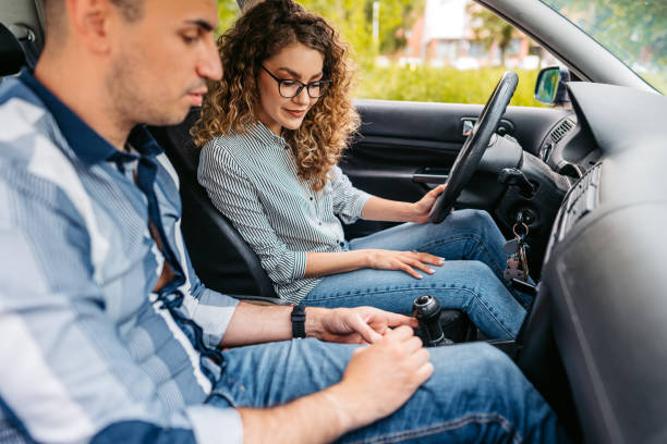 istock Young Woman Having A Driving Lesson With A Male Driving Instructor 1587426954