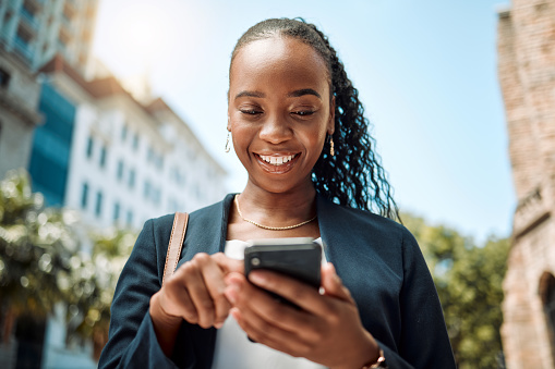 Phone, walking and a business black woman in the city, searching for directions or typing a message. Mobile, smile and gps with a young female employee looking for a location on a navigation app