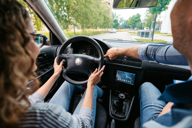 istock Young Woman Having A Driving Lesson With A Male Driving Instructor 1587427123