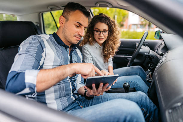 istock Young Driving Instructor Showing His Female Student Driving Test Results On A Tablet 1587428236