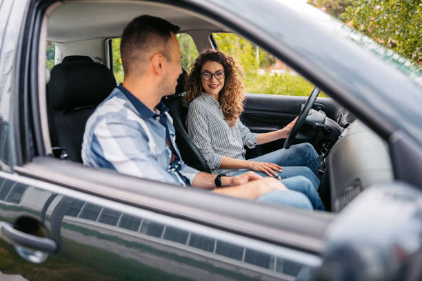 Young Woman Having A Driving Lesson With A Male Driving Instructor