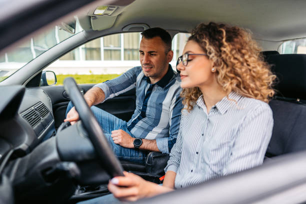 istock Young Woman Having A Driving Lesson With A Male Driving Instructor 1587430428
