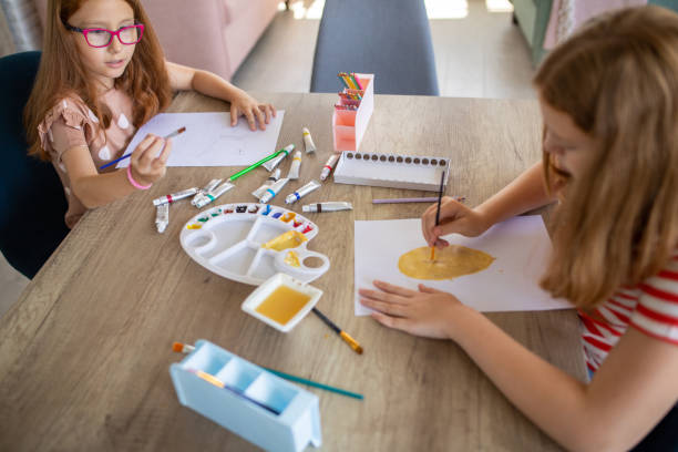 istock Two sisters painting and drawing at home 1587431983