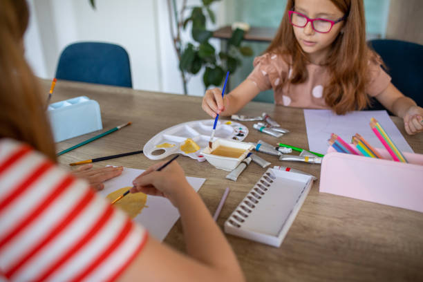 istock Sisters painting together at home 1587431988