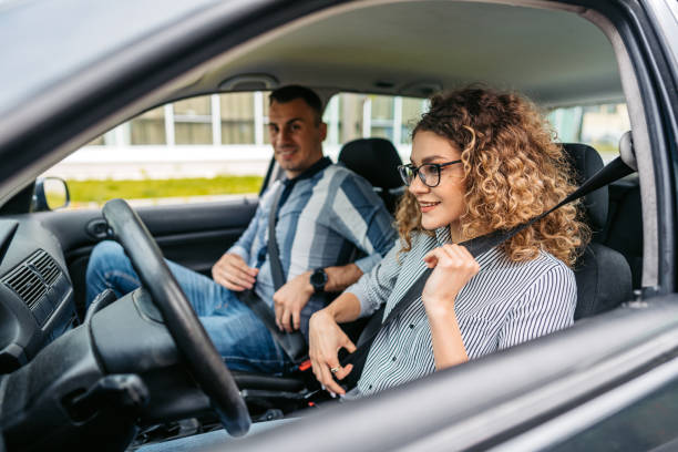 istock Driving Instructor And A Female Student Fastening Their Seatbelts 1587432552