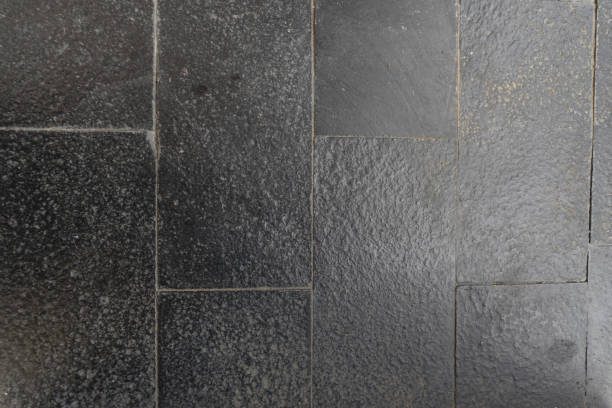 istock Dark grey brick stone tile wall texture detail closeup 1587437443