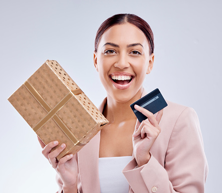 Woman, credit card and gift box for prize, retail giveaway or payment success on studio white background. Happy person or winner portrait with present, finance bonus and shopping sale and e commerce