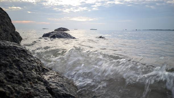 istock Beach water waves come and rocks 1587444552