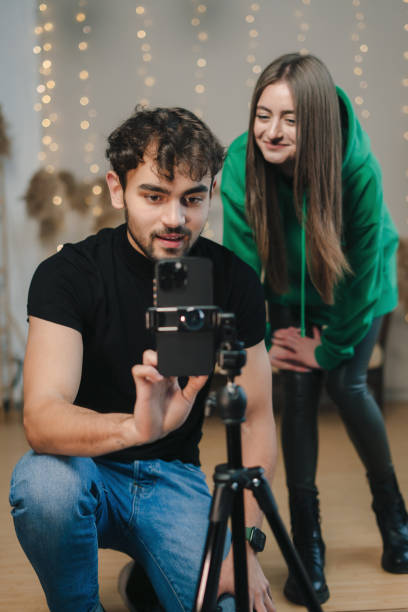 istock Lovely man and girl doing a live streaming while dancing online popular dances. 1587452816