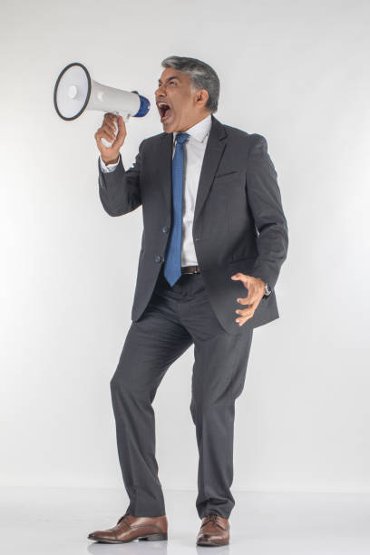 istock Angry professional screaming into megaphone on white background 1587464856