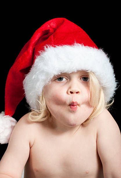 Christmas kiss a cute baby wearing a santa hat ready to kiss lieke klaus stock pictures, royalty-free photos & images