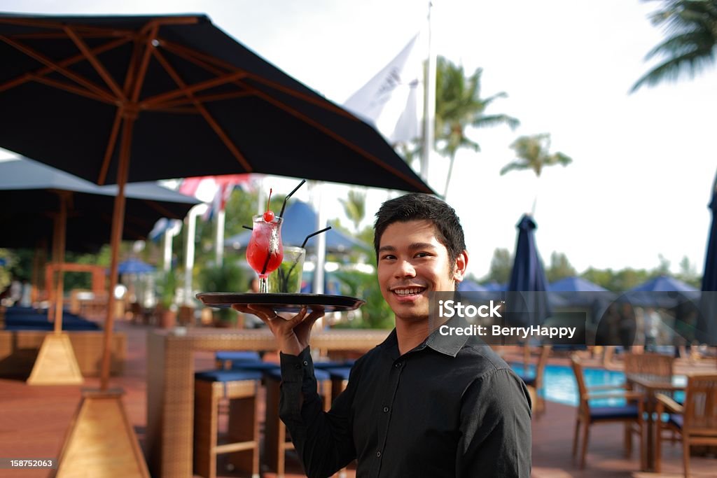 Asian Cameriere che serve i drink a bordo piscina - Foto stock royalty-free di Adulto