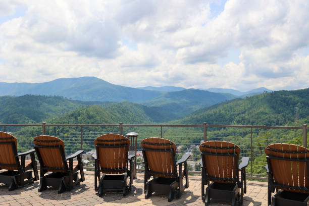 una fila di sedie a dondolo in legno di fronte alle montagne nel tennessee - gatlinburg foto e immagini stock