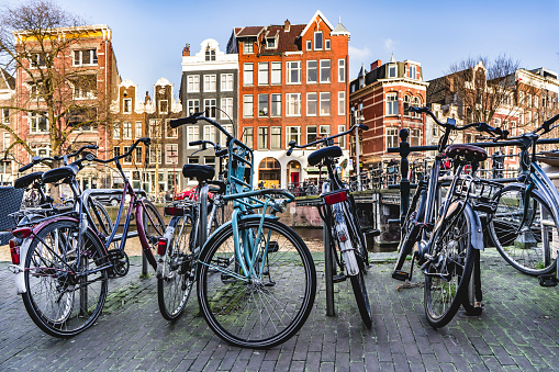 Bicycles parked near a canal in Amsterdam city