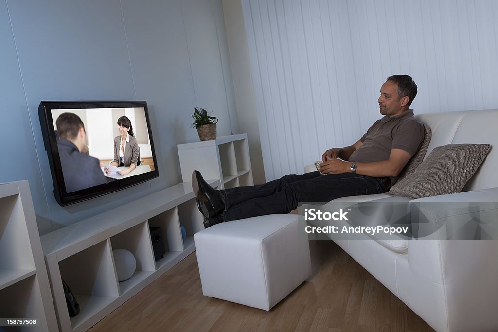 Casa de hombre mirando películas pay-per-view - Foto de stock de Acogedor libre de derechos