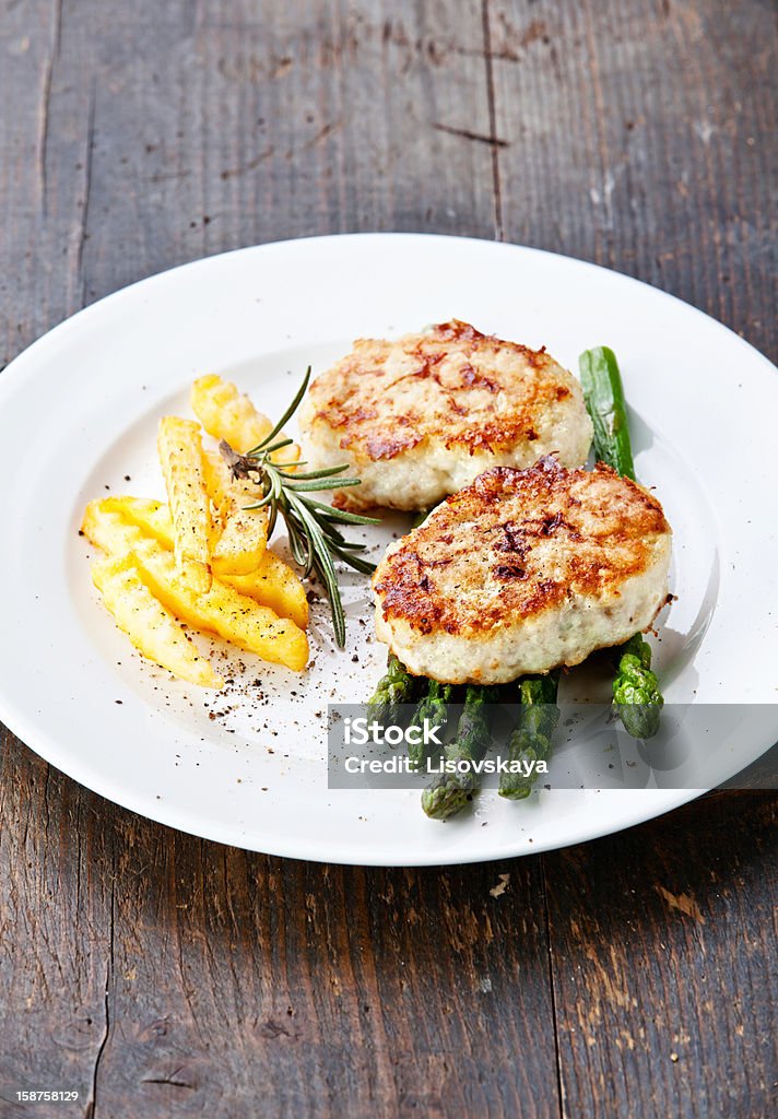 Fishcakes Fishcakes with french fries and asparagus Asparagus Stock Photo