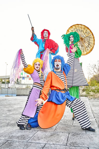istock Excited clowns performing various tricks during festive event in park 1587590754