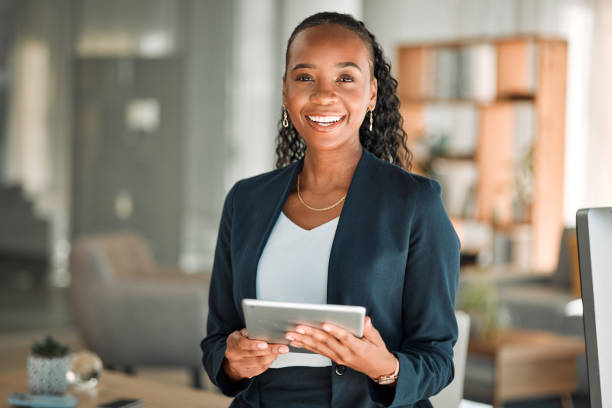 Portrait, lawyer and black woman with tablet, smile and happy in office workplace. African attorney, technology and face of professional, female advocate and legal advisor from Nigeria in law firm. stock photo