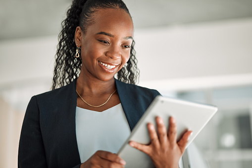 Lawyer, smile and black woman with tablet in office for legal research, online app and social media. African attorney, technology and happy professional reading business email, networking or internet