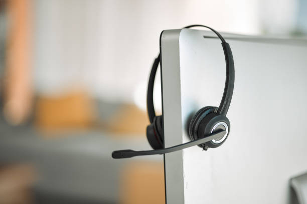 istock Headset, computer and customer service in a call center for support, consulting or telemarketing after hours. Contact, crm and communication equipment in an empty office for help or assistance 1587604275