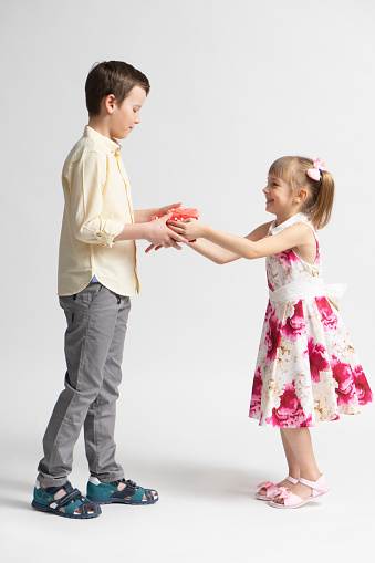 Children's love, a little boy and a girl, having fun, laugh and smile, and kiss outdoors.