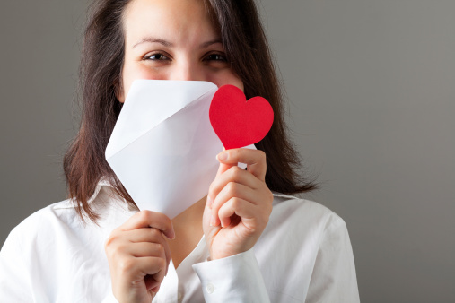 Smiling Woman Holding a Red Heart and an Envelop