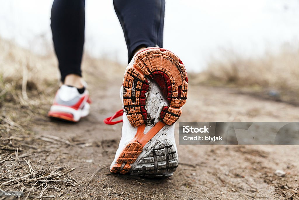 Person in workout pants and sports shoes walking or running Walking or running legs sport shoes, fitness and exercising in autumn or winter nature. Autumn Stock Photo