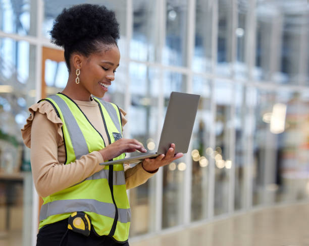 istock Project, woman and contractor with laptop at constriction site with architect or planning with employee. Engineer, working and technology with project management for renovation or maintenance. 1587634761