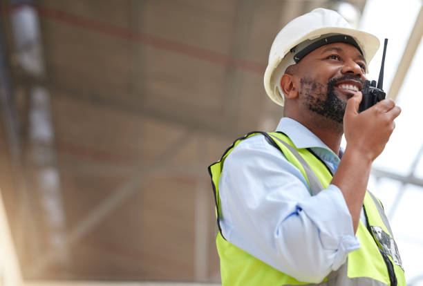 istock Radio, black man and engineer planning, communication and construction. African architect, walkie talkie and happy contractor with industrial project, building maintenance and engineering discussion. 1587635334