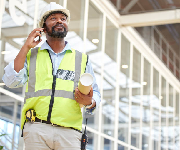 istock Phone call, black man and architect with blueprint, talking and planning to work on construction project. African engineer, mobile technology and contractor speaking, communication and discussion. 1587635855