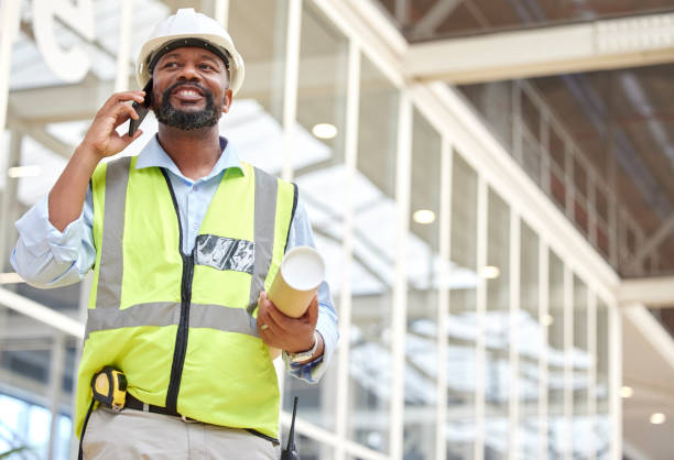 istock Architecture, black man or engineer on a phone call conversation for building construction. Blueprint, industrial or African designer in a discussion networking or speaking of engineering project 1587635857