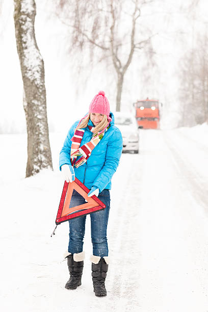 kobieta z odbłyśnikiem trójkąt samochód podział śniegu - car winter road reflector snow zdjęcia i obrazy z banku zdjęć