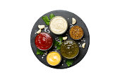 Many different sauces and herbs isolated on white background, flat lay top view. sauces on plate, healthy concept