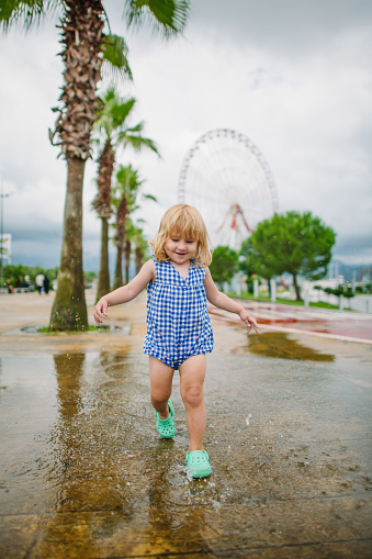 Child running  in a park in summer after rain