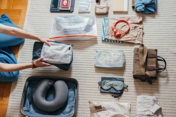 istock Anonymous Woman Packing and Preparing Various Things for her Trip 1587648411
