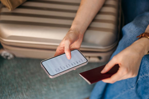 istock Anonymous Woman Checking Her Passport and Using Her Mobile Phone (Copy Space) 1587648450