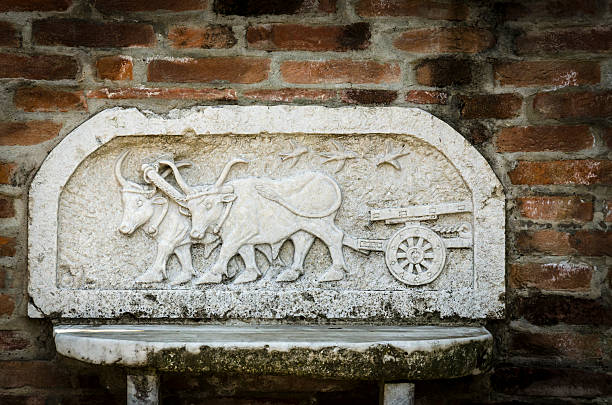 ancient stone bench with a representation of a plow and animals.