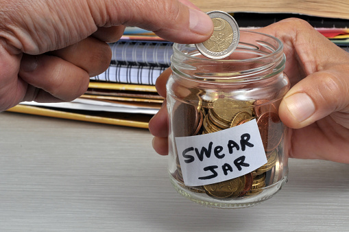 Putting two euros in a glass jar for swearing
